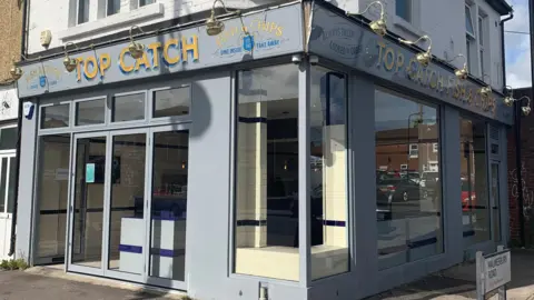 Raj Khaira The outside of the Top Catch store with glass around the building which sits on a street corner.