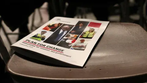 Reuters A close up image of a programme setting out Keir Starmer's 'plan for change' that's been left on an empty seat at the prime minister's speech 