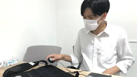 Christine Ro Yoshinori Kato demonstrates the components of a cooling vest
