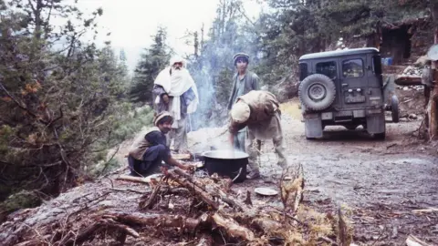 John England Men cooking over a fire