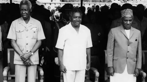 AFP Tanzania's president-elec Ali Hassan Mwinyi (C) poses with the out going President Julius Nyerere (L) and the man who takes over as Zanzibar's President Idris Abdul Wakil (R) on October 1985
