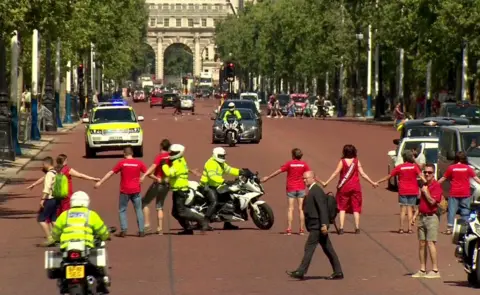 BBC The motorcade bringing Boris Johnson to Buckingham Palace is disrupted by protesters