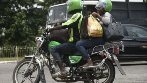 AFP A Nigerian motorbike rider drive through traffic gridlock in Lagos with his passenger