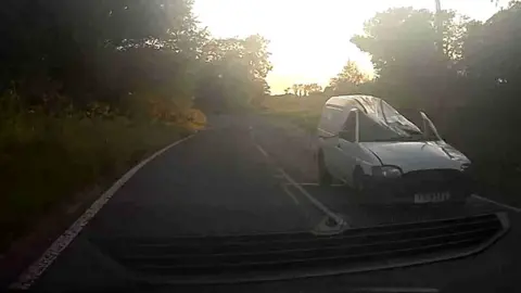 Dented Ford van being driven to scrapyard