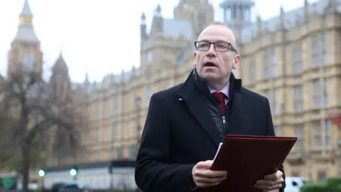 Reuters Secretary of State for Northern Ireland Chris Heaton-Harris delivers a statement to media members near the Houses of Parliament is expected to update parliament on the deal