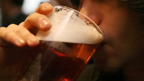 PA Media Man drinking pint of beer