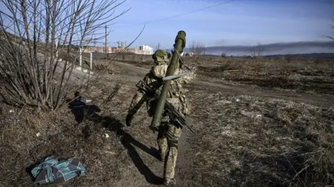 A Ukrainian serviceman walks towards the front line in Irpin last year