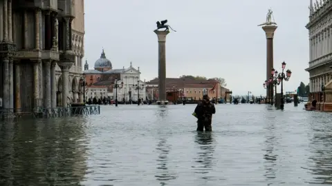 Reuters A man stands in water at the flooded St Mark"s Square