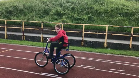 Family photo James doing accessible cycling