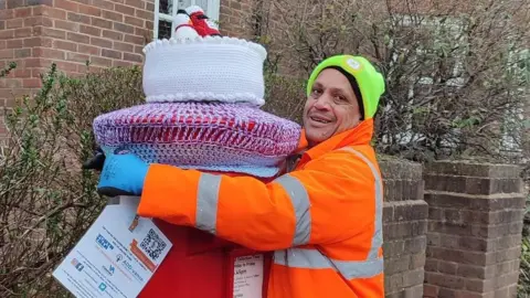 St Albans Postboxes Man putting a post box topper on a post box