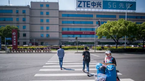 AFP/Getty his picture taken on May 3, 2018 shows the ZTE logo on an office building in Shanghai. - Chinese telecom giant ZTE said its major operations had 'ceased' following last month's US ban on American sales of critical technology to the company, raising the possibility of its collapse.