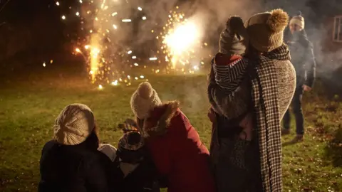 Getty Images People lighting fireworks in their garden