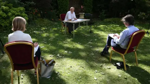 Jonathan Brady/Getty Images Dominic Cummings sits at a table with journalists in the foreground