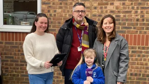 BBC From left: Tiffany (parent with children at the school), head Anthony Evans, eight-year-old Bella and deputy head Lauren Hayden