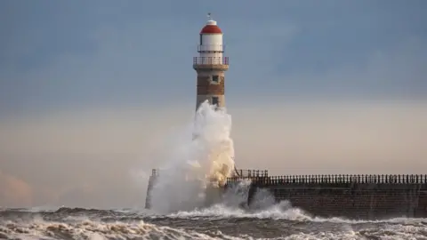 Simon C Woodley Waves break around lighthouse at Roker