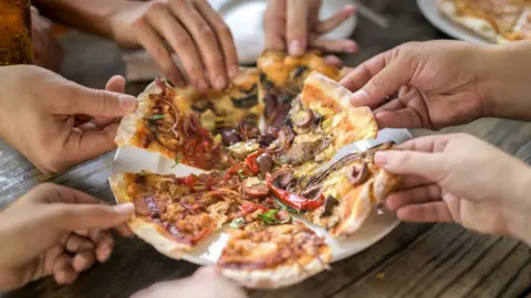 Getty Images Generic pic of people helping themselves to pizza