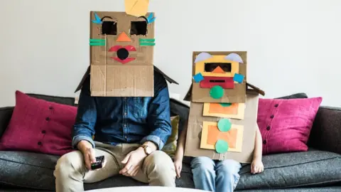 Getty Images Man and child with boxes on their heads