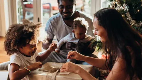 Getty Images Family opening Christmas presents