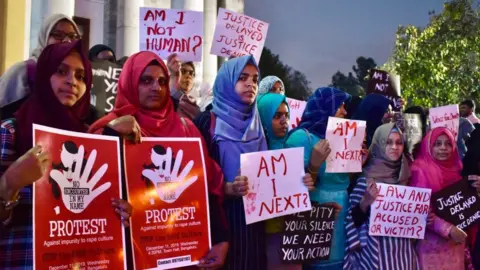 Getty Images Activists from various women's rights organisations hold placards as they protest against sexual harassment, rapes and murders of women across the country urging the government to help uphold the women's rights, during a demonstration in Bangalore on December 11, 2019.