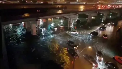 Reuters Cars driving on flooded streets