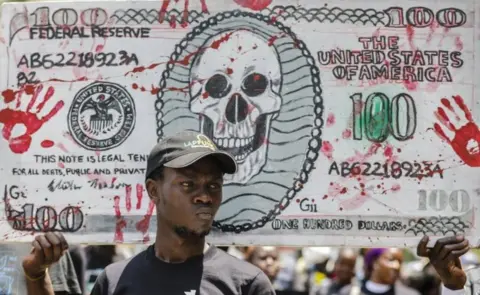 EPA Kenyan activists raise a mock US dollar bill during a protest against the politicians and leaders of war-torn South Sudan, in Nairobi, Kenya, 11 October 2018.