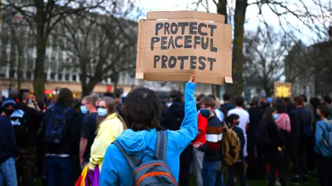 Demonstrators hold placards during a 'Kill The Bill' protest against the Government's Police, Crime, Sentencing and Courts Bill, in Bristol south west England on 30 March 2021