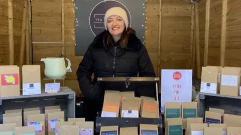 Emily standing behind all of her tea products