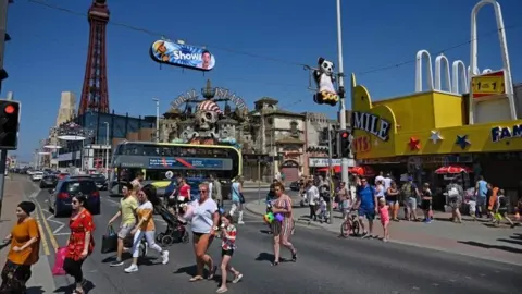 AFP/Getty Images People walking across the promenade in Blackpool