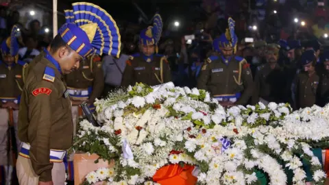 Reuters Central Reserve Police Force (CRPF) officers bow to pay tribute next to a coffin containing the remains of their colleague Bablu Santra in Howrah, West Bengal