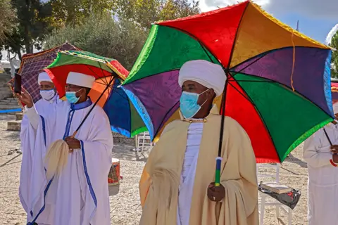 Getty Images Israeli religious leaders (Kessim) of the Ethiopian Jewish community recite prayers during the Sigd holiday, marking the desire to "return to Jerusalem", as they celebrate from a hilltop in the holy city, on November 16, 2020 amid restrictions to their usual celebration to limit the spread of the Covid-19 coronavirus