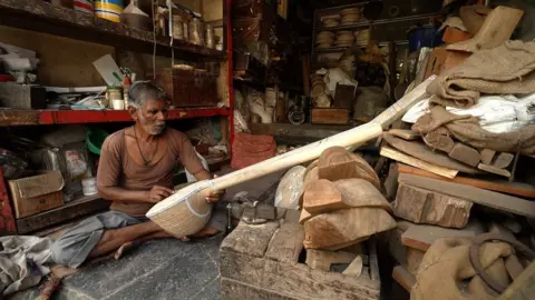 BBC/ Sharad Badhe An artisan working on a sitar