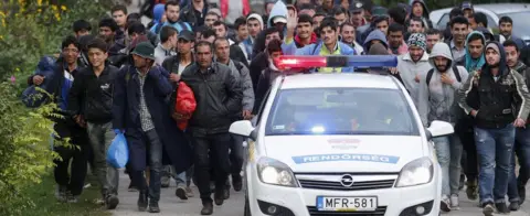 Reuters Hungarian police lead migrants on their way to Austria, in Hegyeshalom, Hungary, September 27, 2015