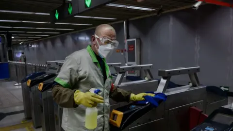 Getty Images A man disinfects the subway in China