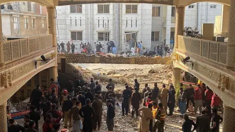 Getty Images Security officials inspect the site of a mosque blast inside the police headquarters in Peshawar on January 30, 2023.