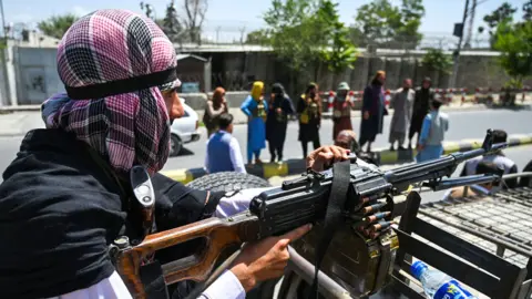 AFP A Taliban fighter mans a machinegun on top of a vehicle as they patrol along a street in Kabul on 16 August 2021