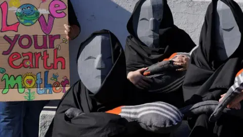Nic Bothma/ Reuters Women take part in a mothers climate justice protest organised by climate action group Extinction Rebellion in Cape Town, South Africa, May 13, 2023.
