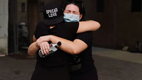 Getty Images People embrace during the coronavirus pandemic on May 29, 2020 in New York City