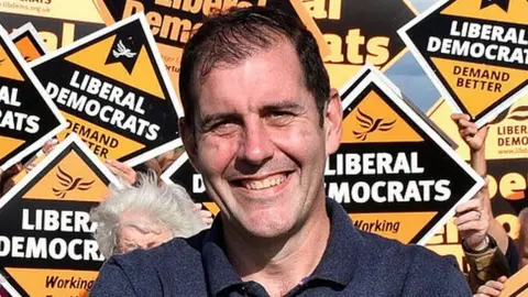 Liberal Democrats Lee Dillon surrounded by Liberal Democrat campaign signs