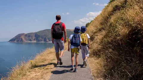 Getty Images Dad and two boys on coastal walk