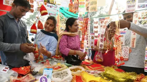Getty Images PATNA, INDIA - OCTOBER 23: People shop for essentials at Bailey road on the eve of Diwali, on October 23, 2022 in Patna, India. (Photo by Santosh Kumar/Hindustan Times via Getty Images)
