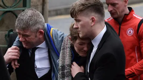 Getty Images Morgan Barnard's mother Marie is comforted at her son's funeral service