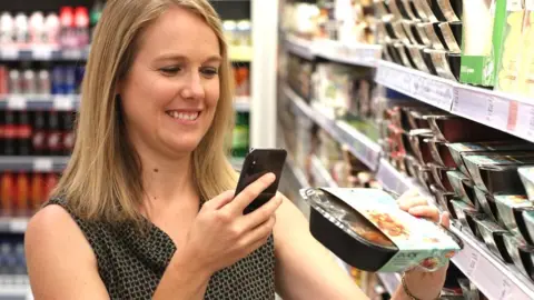 Sainsbury's A shopper scanning a product with a smartphone