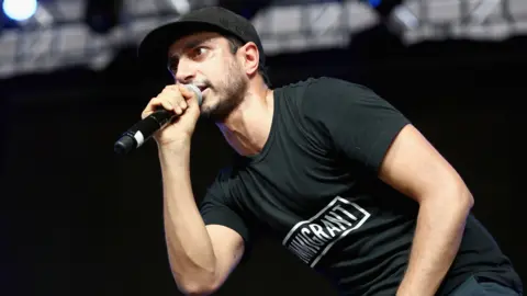 Getty Images Riz Ahmed on stage in 2017