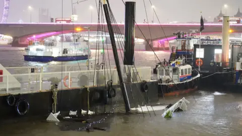 PA Media The mast of the Bar & Co boat, which was moored at Temple Pier juts from the water after the London party boat which acts as a floating bar, restaurant and nightclub sunk in the River Thames.