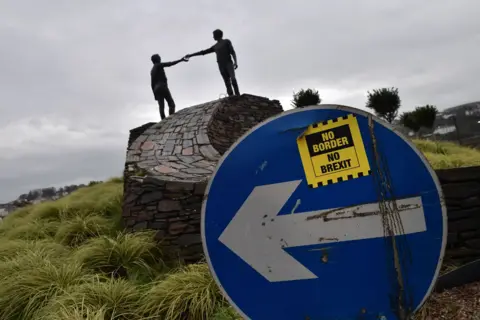 Getty Images A No Border No Brexit sticker close to the Hands Across the Divide peace statue