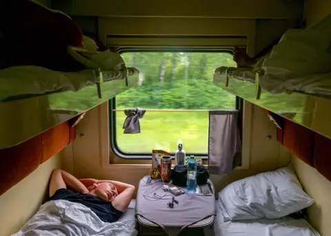 Peter Dench Passengers asleep in a second-class cabin on the Trans-Siberian Railway