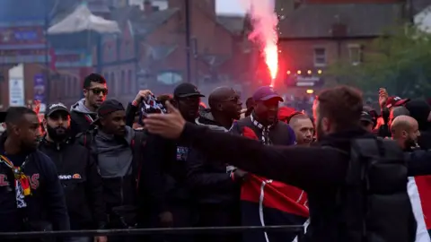 PA Media/Owen Humphreys Paris Saint-Germain fans holding a flare