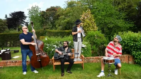 Reuters Todd Sharpville and his band jam in a garden as they isolate together with their families and pets