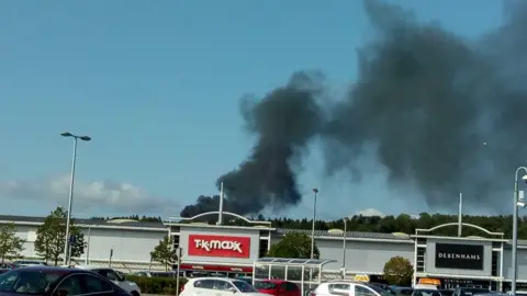 Clare Davies Smoke from the fire behind shops