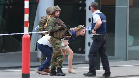 AFP Soldiers and police officials guide members of the public on a street in Brussels, 20 June